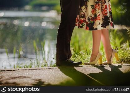 Couple kissing outdoors - Lovers on a romantic date at sunset,girls stands on tiptoe to kiss her man - Close up on shoes.. girls stands on tiptoe to kiss her man - Close up on shoes. selective focus