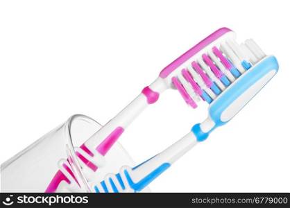 couple kissing toothbrushes in a glass on a white background