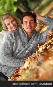 Couple laid in fallen leaves