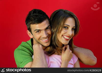 Couple laughing in front of red background