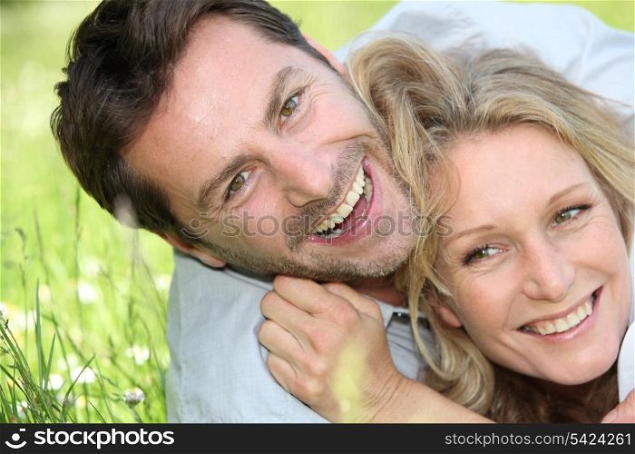 Couple laughing on the grass.