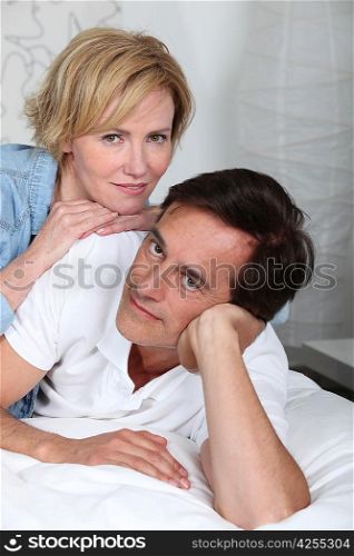 Couple laying down on bed
