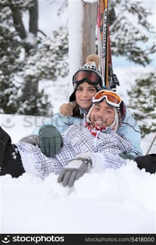 Couple laying down whilst on skiing trip