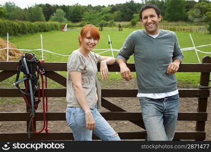 Couple Leaning Against Fence