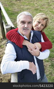 Couple leaning against fence