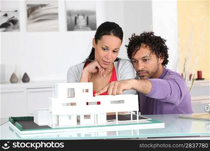 Couple looking at an architect model of a new development