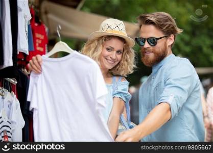 couple looking at clothes in a summer street market