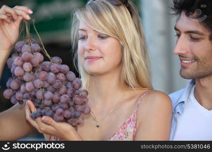 couple looking at huge bunch grapes