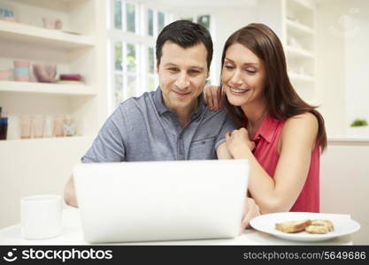 Couple Looking at Laptop Over Breakfast