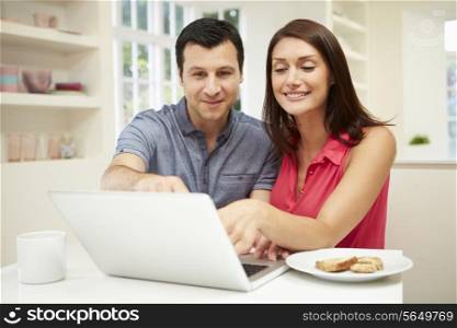 Couple Looking at Laptop Over Breakfast