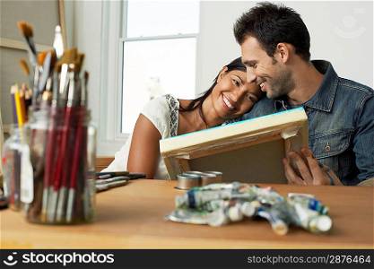 Couple Looking at Painting in Studio