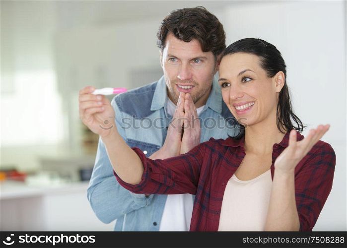couple looking at positive home pregnancy test