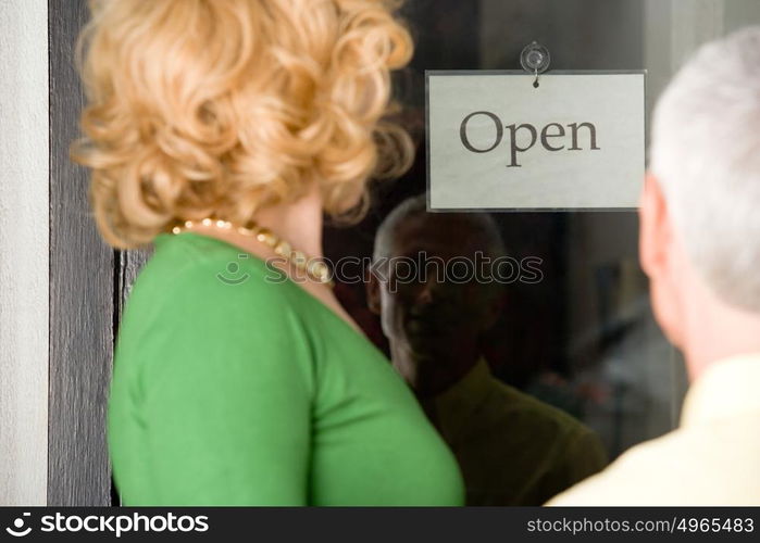 Couple looking at sign in shop window