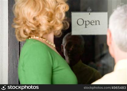 Couple looking at sign in shop window