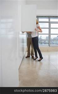 Couple looking in cupboard in empty apartment