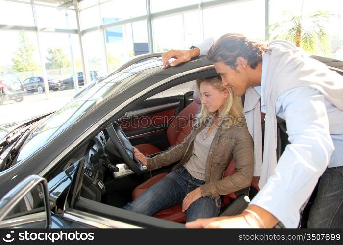 Couple looking inside new car