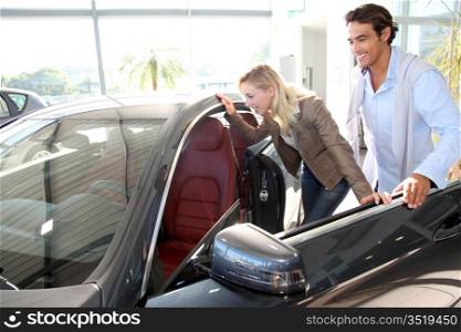 Couple looking inside new car
