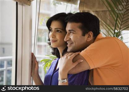 Couple looking out of a bedroom window