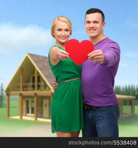 couple, love and family concept - smiling couple holding big red heart