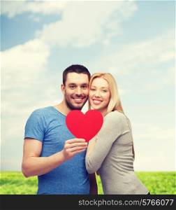 couple, love and family concept - smiling couple holding big red heart
