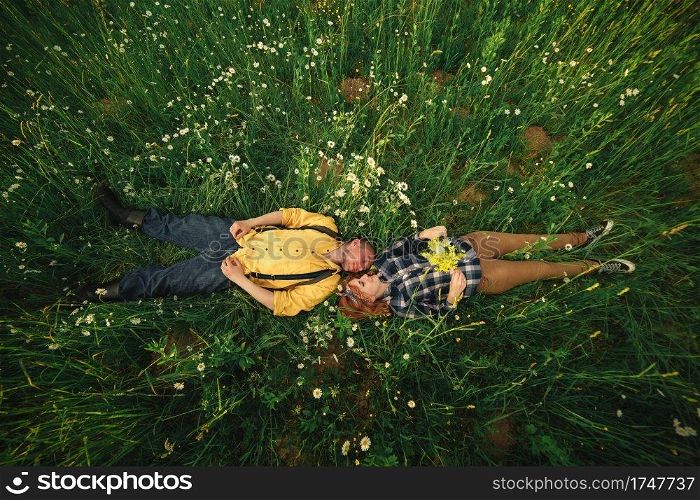 couple lying in a field of flowers. Happy couple lie in a flower. Romance, emotional and love scene. couple lying in a field of flowers. Happy couple lie in a flower. Romance, emotional and love scene.