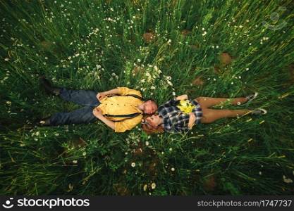 couple lying in a field of flowers. Happy couple lie in a flower. Romance, emotional and love scene. couple lying in a field of flowers. Happy couple lie in a flower. Romance, emotional and love scene.