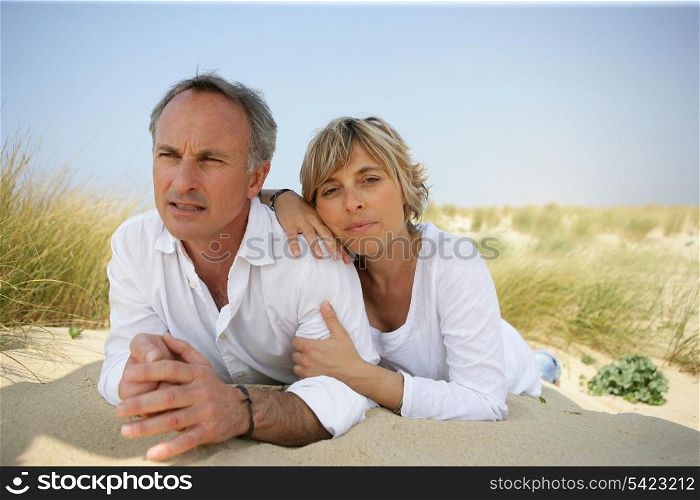 Couple lying in a sand dune