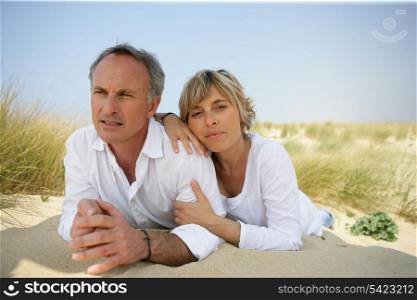Couple lying in a sand dune