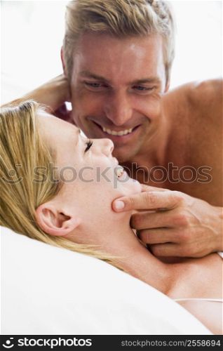Couple lying in bed smiling