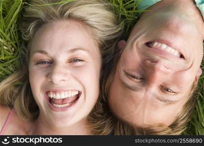 Couple lying in grass smiling