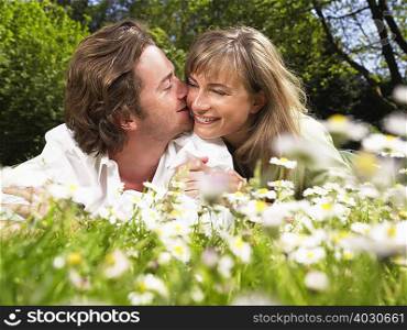 Couple lying in the grass smiling