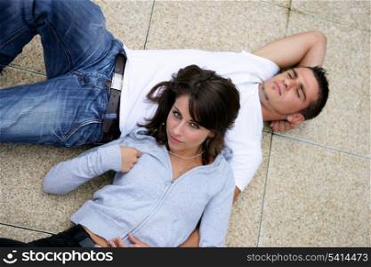 Couple lying on a pavement