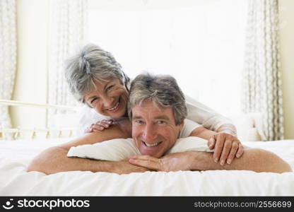 Couple lying on bed together smiling