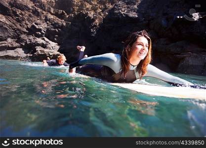 Couple lying on surfboards in the water