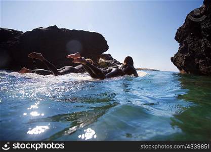 Couple lying on surfboards in the water