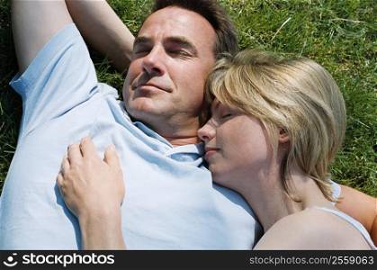 Couple lying outdoors sleeping