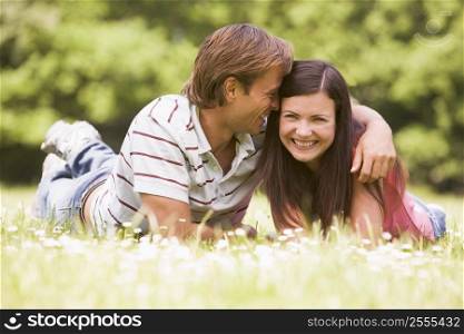Couple lying outdoors smiling