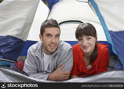 Couple lying side by side in tent, portrait