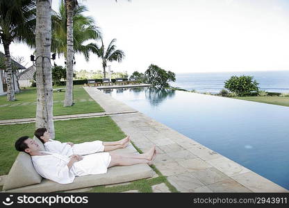 Couple lying together on Chaise Longue outdoors