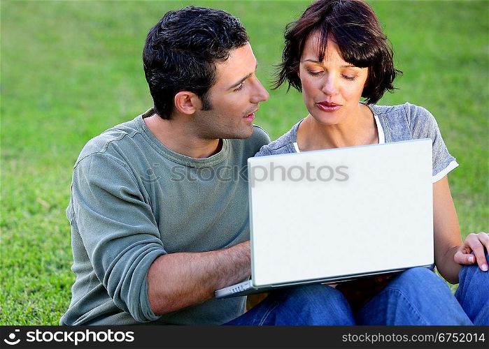 Couple making use of free wifi in the park