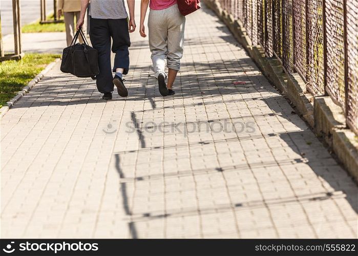 Couple man and woman with sport gym bags walking outdoor. Active young girl and guy in training suit sportswear.. Couple man and woman walking with sport bags.