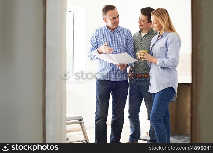 Couple Meeting With Architect Or Builder In Renovated Property