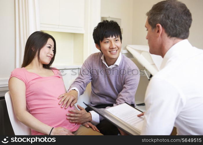 Couple Meeting With Obstetrician In Clinic