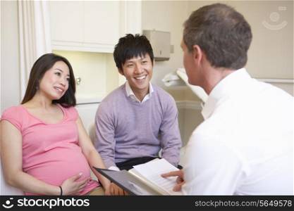 Couple Meeting With Obstetrician In Clinic