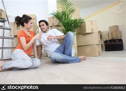 Couple moving in to flat drinking champagne