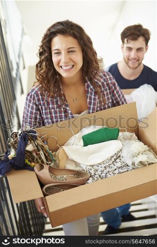 Couple Moving Into New Home Carrying Box Upstairs