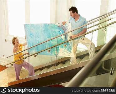 Couple Moving Modern Painting Up Stairway