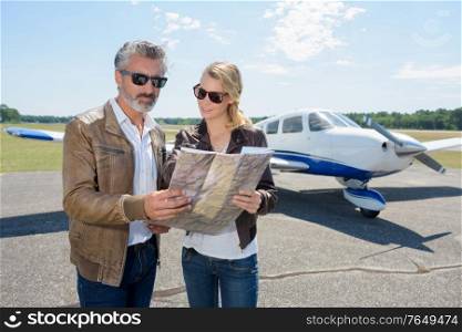 couple near the aircraft looking at map