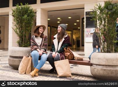 Couple od friends sitting on the city bench