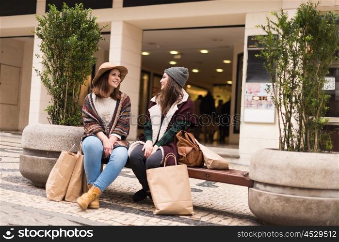 Couple od friends sitting on the city bench